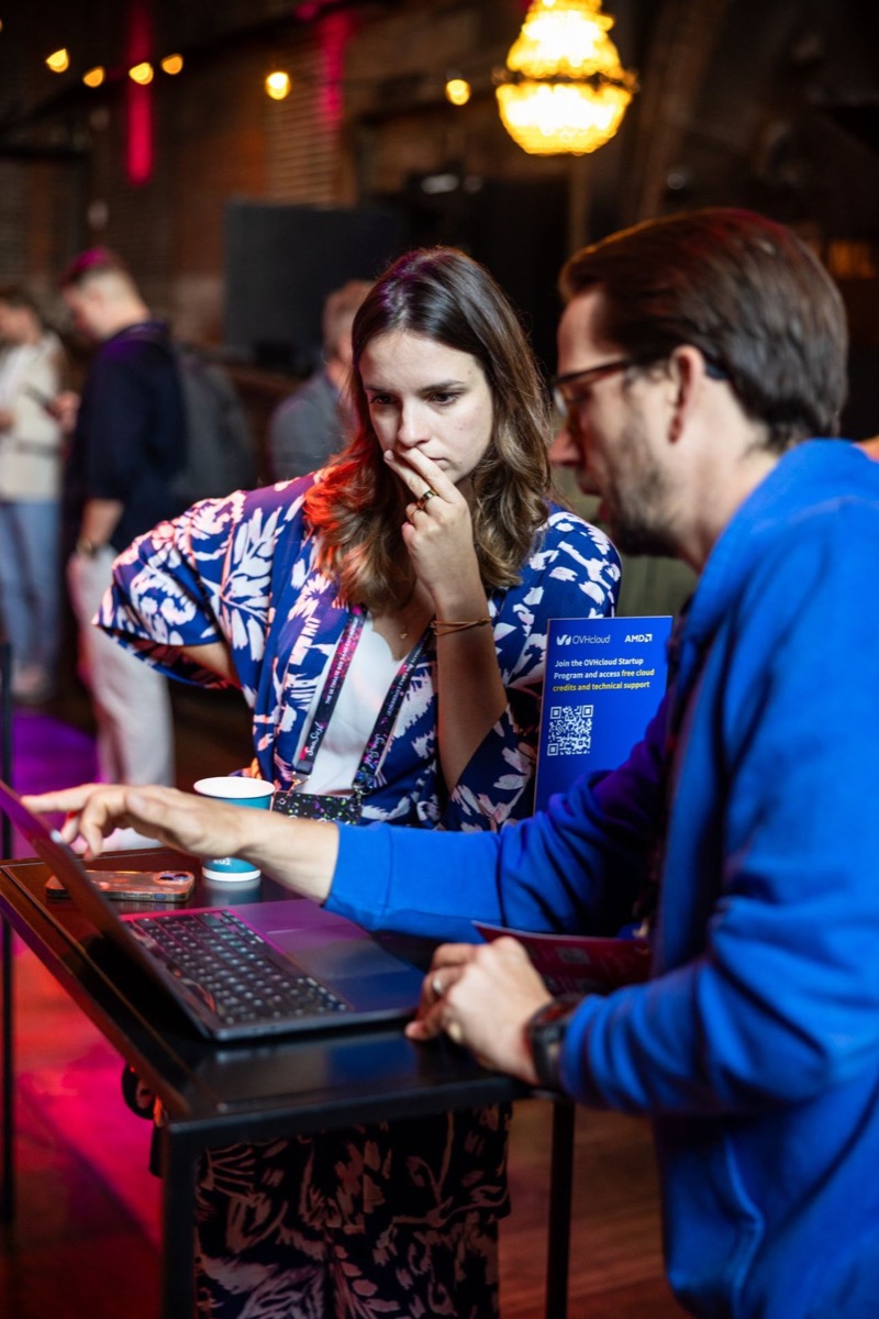 Carolina helping an event attendee work through a task on a laptop