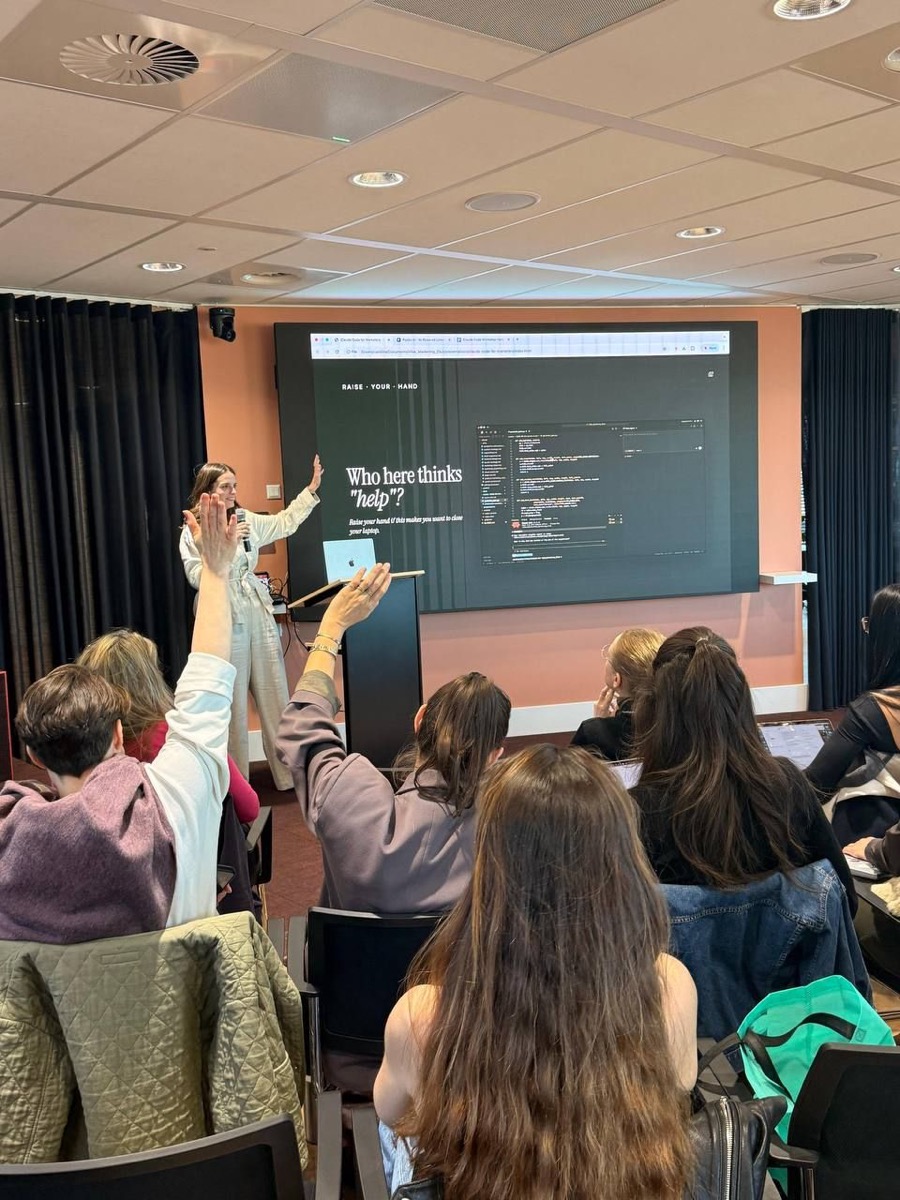Carolina leading a workshop while participants raise their hands
